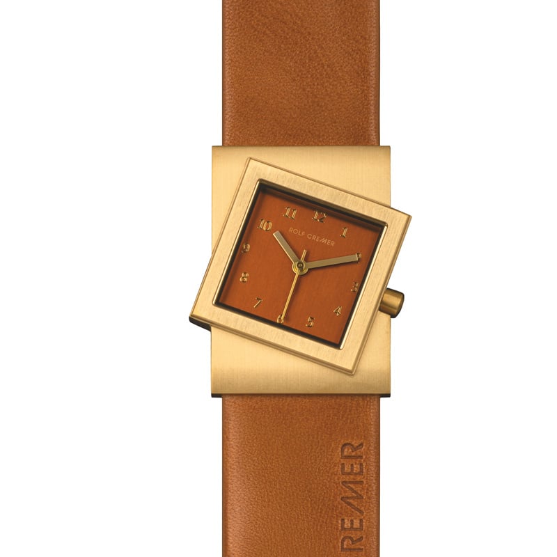 Reloj cuadrado dorado con esfera marrón y correa de cuero marrón.