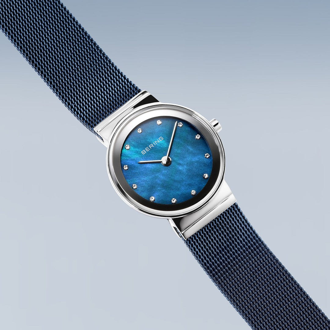 Maak kennis met de Bering 10126-307, een strak polshorloge met een blauwe wijzerplaat, minimalistische uurmarkeringen en gepolijste zilveren lunette. Het beschikt over een donkerblauwe roestvrijstalen meshband, betrouwbaar quartz-uurwerk en duurzaam saffierglas.