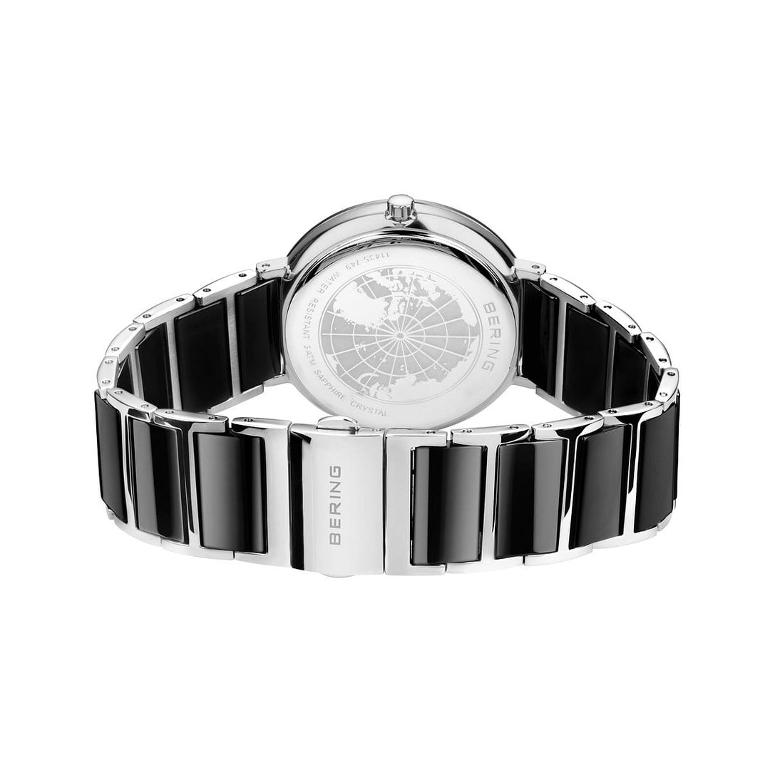 Achteraanzicht van Berings 11435-749 horloge, met een zilveren en zwarte keramische band en een ingewikkeld gegraveerde wereldkaart op de kast. Aangedreven door nauwkeurig Quartz-uurwerk, siert Bering de bandschakels, wat het strakke, moderne ontwerp compleet maakt.