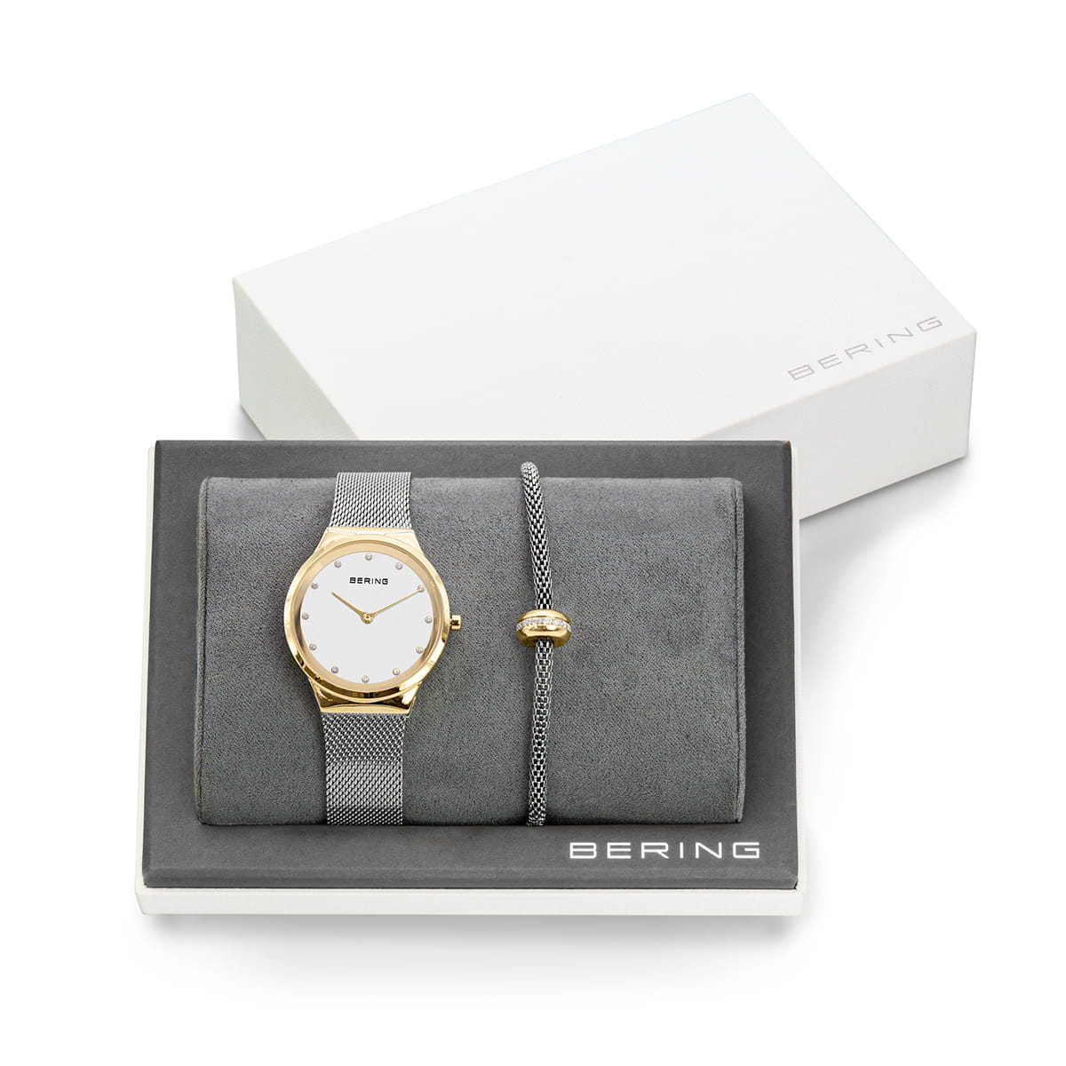 Reloj con esfera blanca, correa gris y detalles dorados, presentado en caja con pulsera a juego.