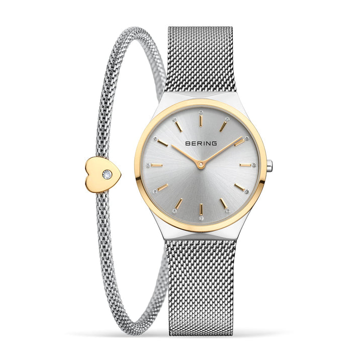 Het Bering horloge (12131-014-GWP) heeft een zilveren mesh band met gouden accenten, een bijpassende armband met een gouden hartbedel en diamant, een minimalistische zilveren wijzerplaat met een quartz uurwerk beschermd door saffierglas en elegante gouden uurmarkeringen.