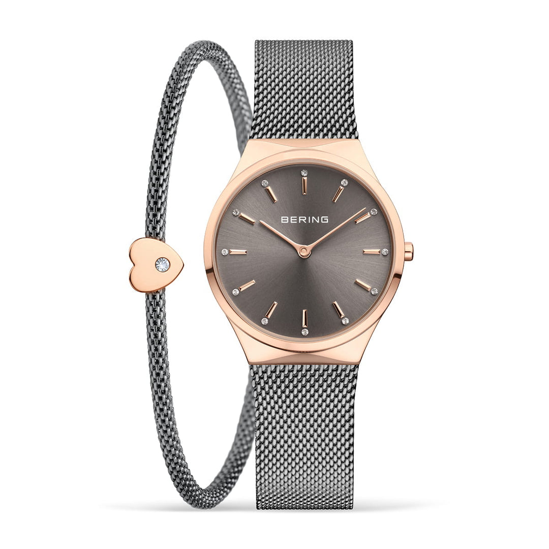 Ervaar de elegantie van de Bering 12131-369-GWP met zijn minimalistische grijze wijzerplaat, roségouden accenten, Milanees-band en bijpassende armband met hartbedel, perfect voor elke gelegenheid.