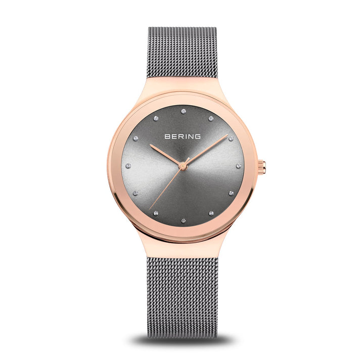 Het elegante Bering dameshorloge 12934-369 heeft een roségouden kast, een minimalistische grijze wijzerplaat met zilveren puntmarkeringen, BERING op de wijzerplaat, een Quartz-uurwerk en een bijpassende grijze mesh-band.