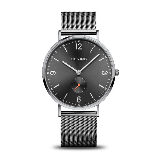 Reloj de hombre Bering con esfera gris, correa de malla metálica y detalles en naranja.