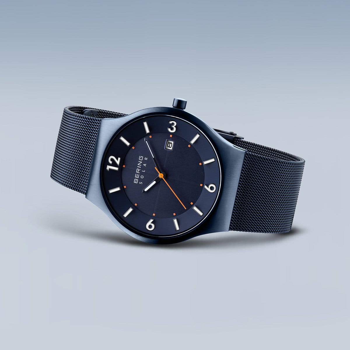 Het Bering 14440-393 horloge is voorzien van Saffierglas voor krasbestendigheid, een strak marineblauw ontwerp met een mesh band en een ronde wijzerplaat met grote witte cijfers, oranje minutenmarkeringen en een datumweergave op 6 uur. Het Solar-uurwerk mechanisme zorgt ervoor dat het tijdloze elegantie belichaamt.