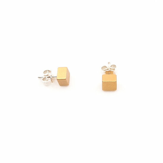 Pendientes de cubo en color albaricoque con base de metal plateado.