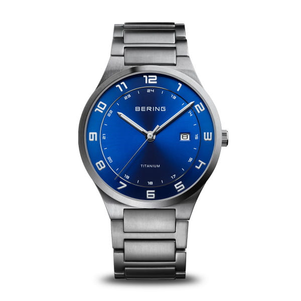 Reloj de titanio con esfera azul y correa de acero inoxidable, números en relieve y fecha.