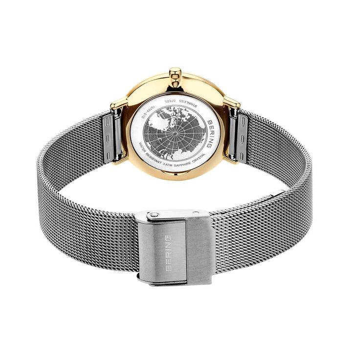 De afbeelding toont een Bering horloge, model 15729-010, van de achterkant. Het heeft een zilveren mesh band met een sluiting met het Bering merk in reliëf. De goudkleurige roestvrijstalen kast is voorzien van kaartgravures van verschillende wereldsteden.