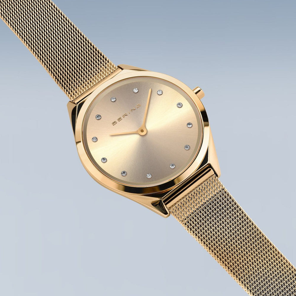Het Bering 17031-333 dameshorloge heeft een strak gouden design tegen een lichtblauwe achtergrond met een sunburst wijzerplaat, met kristal versierde uurmarkeringen en een delicate mesh band. Uitgerust met saffierglas en quartz uurwerk, biedt het elegantie en precisie.