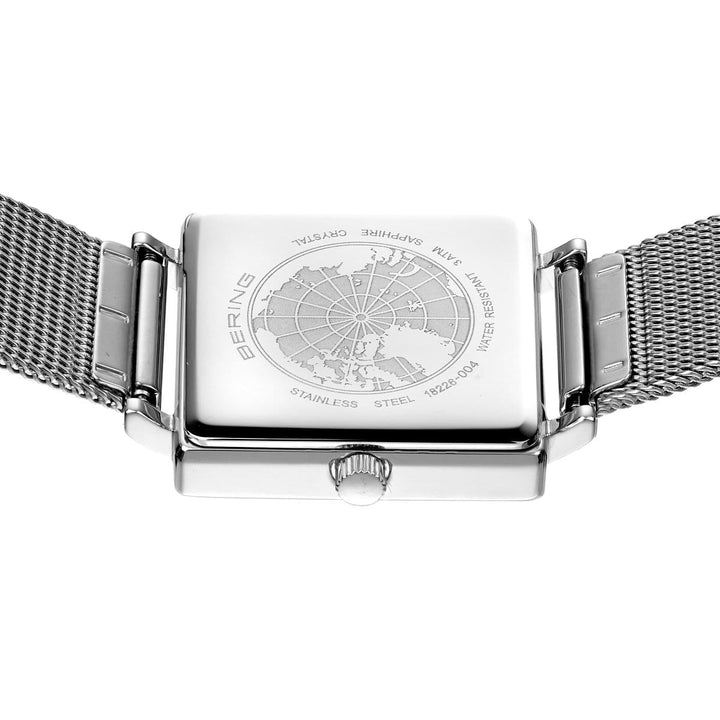 De achterkant toont een vierkante zilveren kast met een globe ets, roestvrijstalen mesh band, saffierglas, quartz uurwerk en gelabelde materiaal- en waterbestendigheidsdetails. Dit is het Bering dameshorloge met witte wijzerplaat - 18226-004.