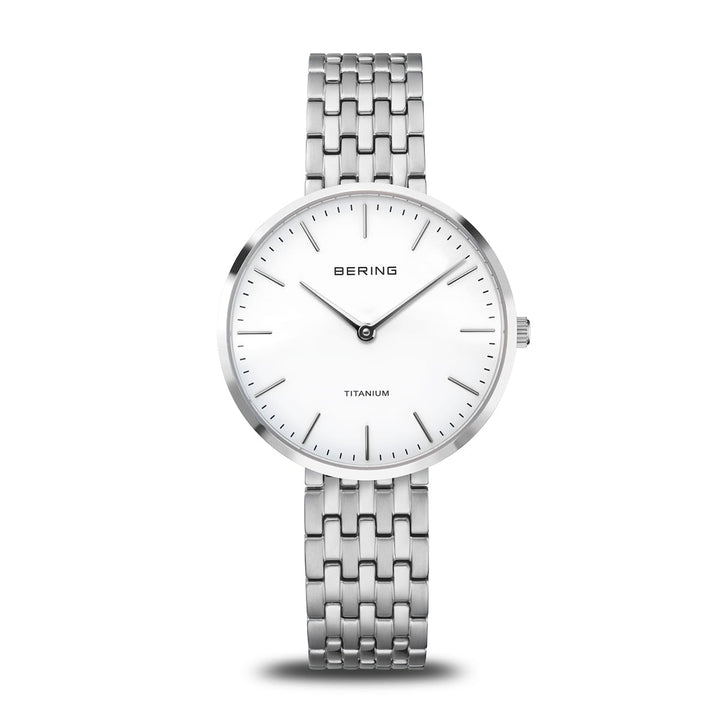 Het Bering dameshorloge 19334-004 heeft een minimalistisch design met een witte wijzerplaat, zwarte markeringen en minutenwijzers, TITANIUM op de wijzerplaat en een zilveren schakelband. Het saffierglas kristal verbetert de duurzaamheid van dit elegante uurwerk.