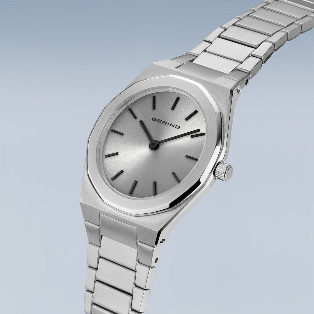 Het Bering dames horloge zilveren dial - 19632-700 heeft een strak minimalistisch design met een ronde wijzerplaat, dunne uurmarkeringen en BERING op de wijzerplaat. De zilveren metalen schakelband combineert prachtig met saffierglas, allemaal tegen een lichtblauwe achtergrond met kleurverloop.