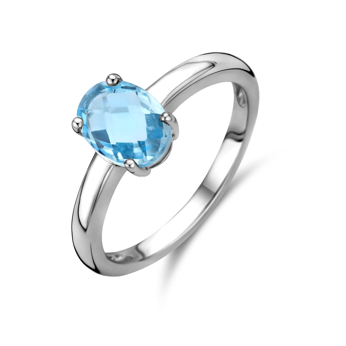 Anillo de plata rodiada con topacio azul ovalado en engaste de cuatro garras.