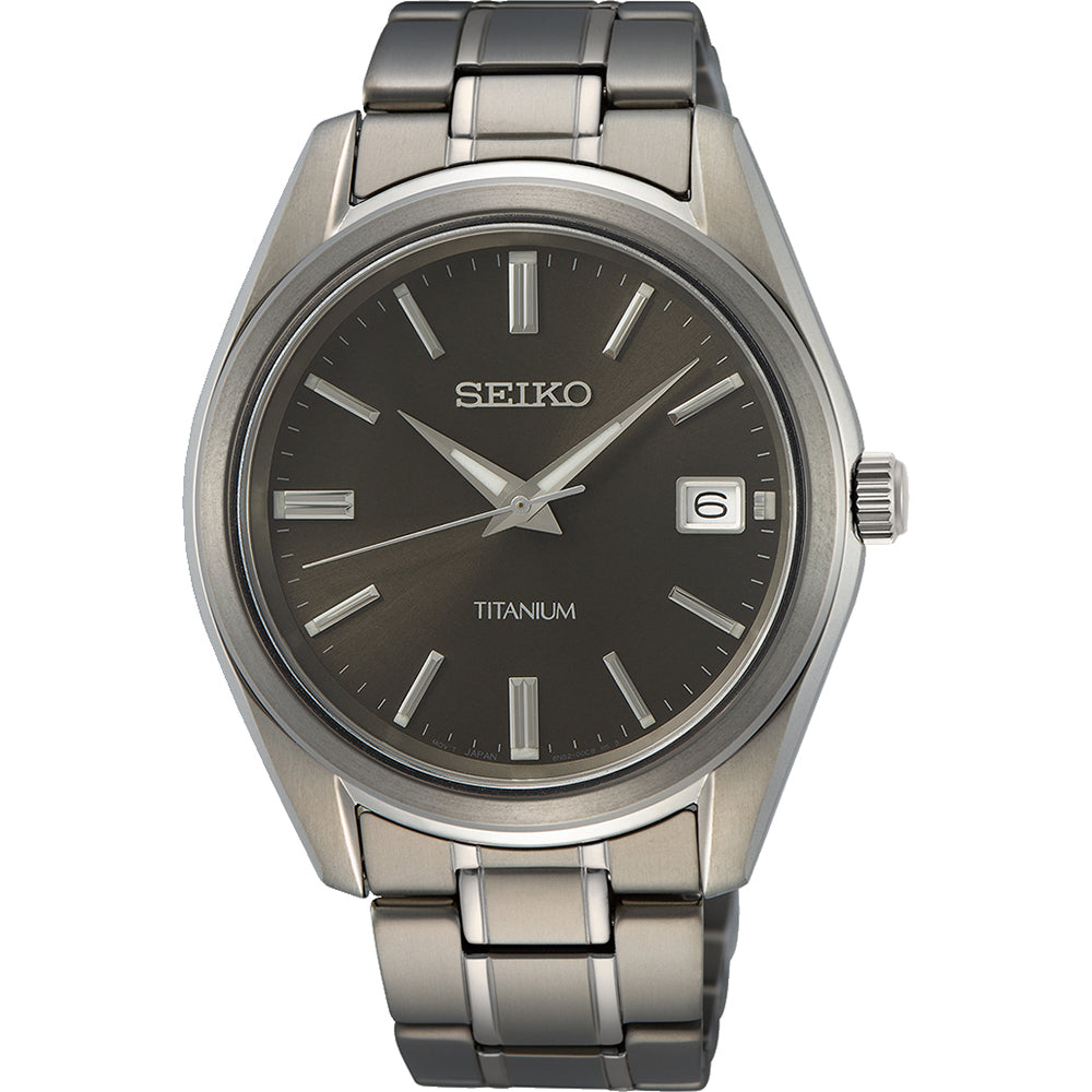 Reloj de hombre Seiko con caja de titanio, esfera negra y correa de eslabones en tonos grises.