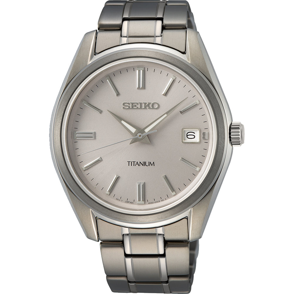 Reloj de hombre Seiko con caja de titanio, esfera plateada y correa de eslabones en tonos grises.