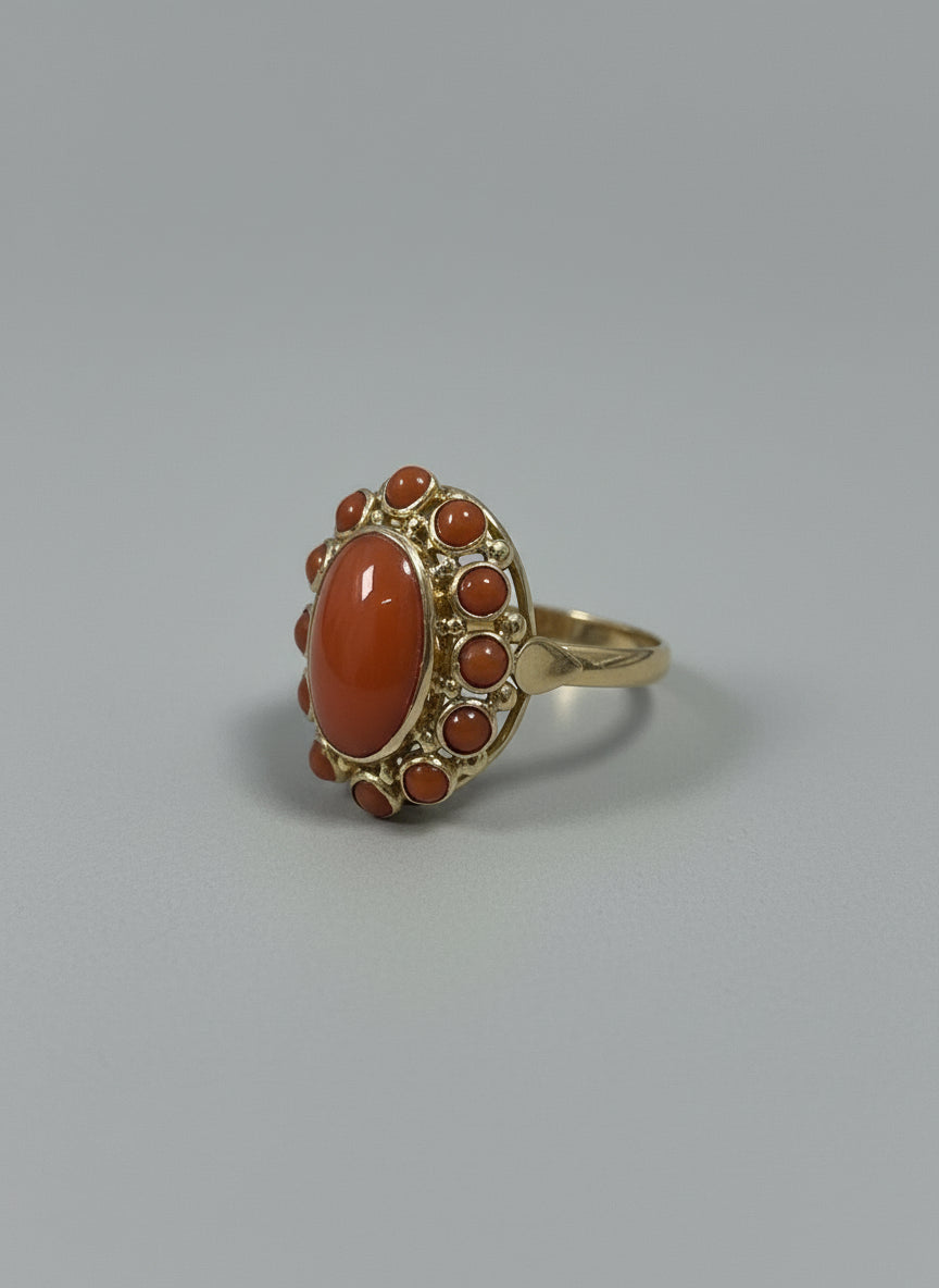 Anillo vintage de oro de 14k con coral rojo y detalles de piedras alrededor.