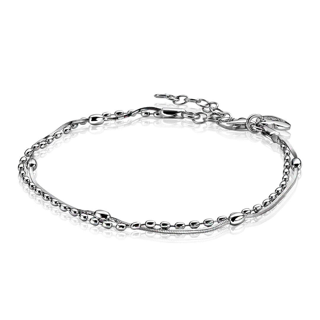 De Zinzi Armband Zilver Zia1345 is een delicate zilveren armband met kleine ronde kralen, gladde schakels en een verstelbare sluiting voor een multi-look stijl. Het heeft een reflecterende afwerking en rust op een effen witte achtergrond.