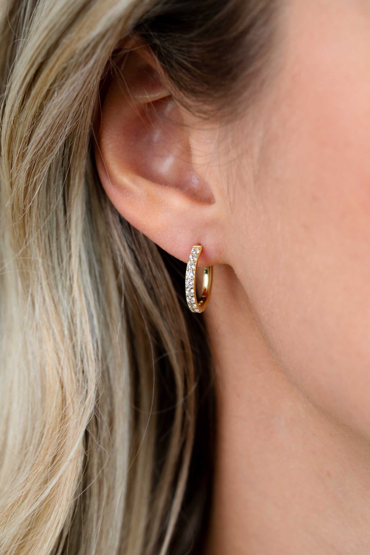 Pendientes de aro dorados con detalles de piedras brillantes, de 15 mm de diámetro.
