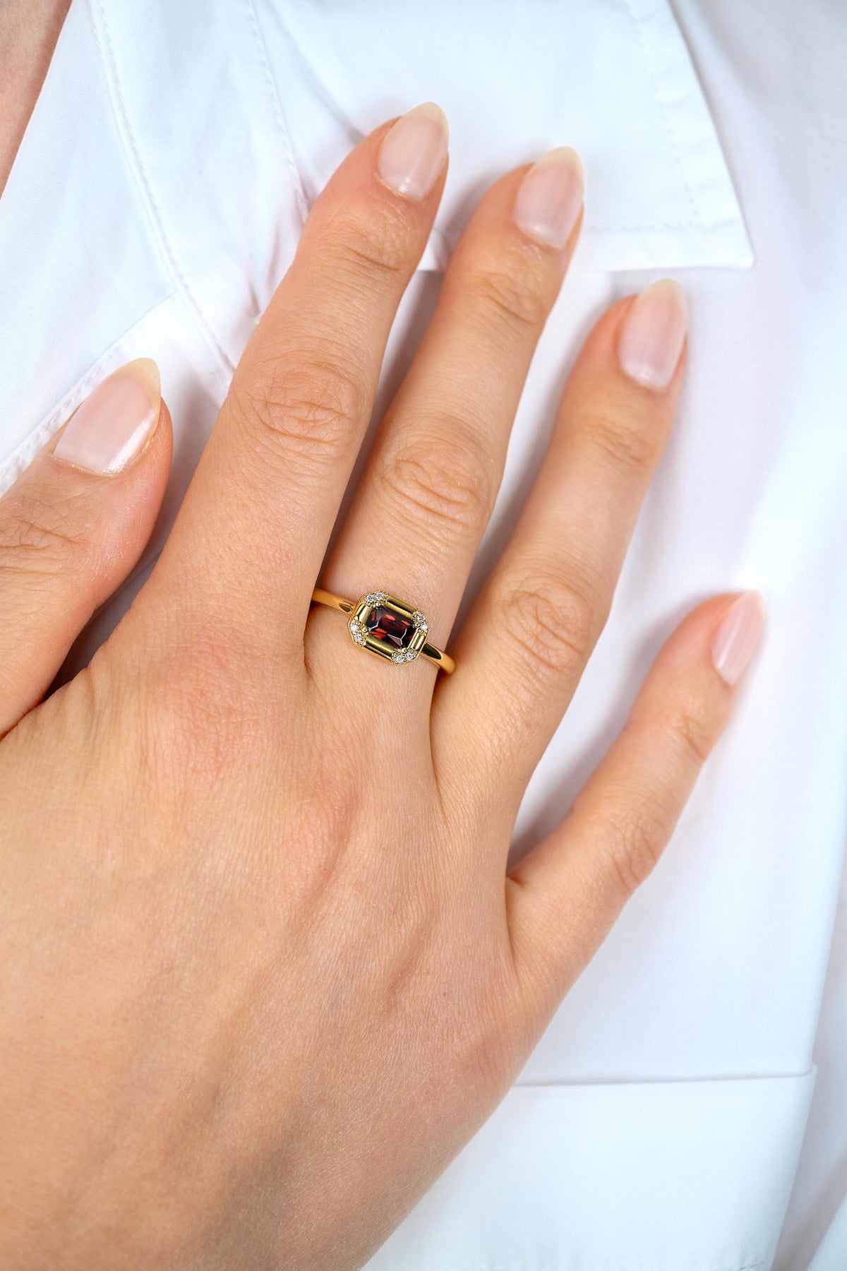 Anillo de plata bañado en oro con una piedra central rectangular de colores variados.