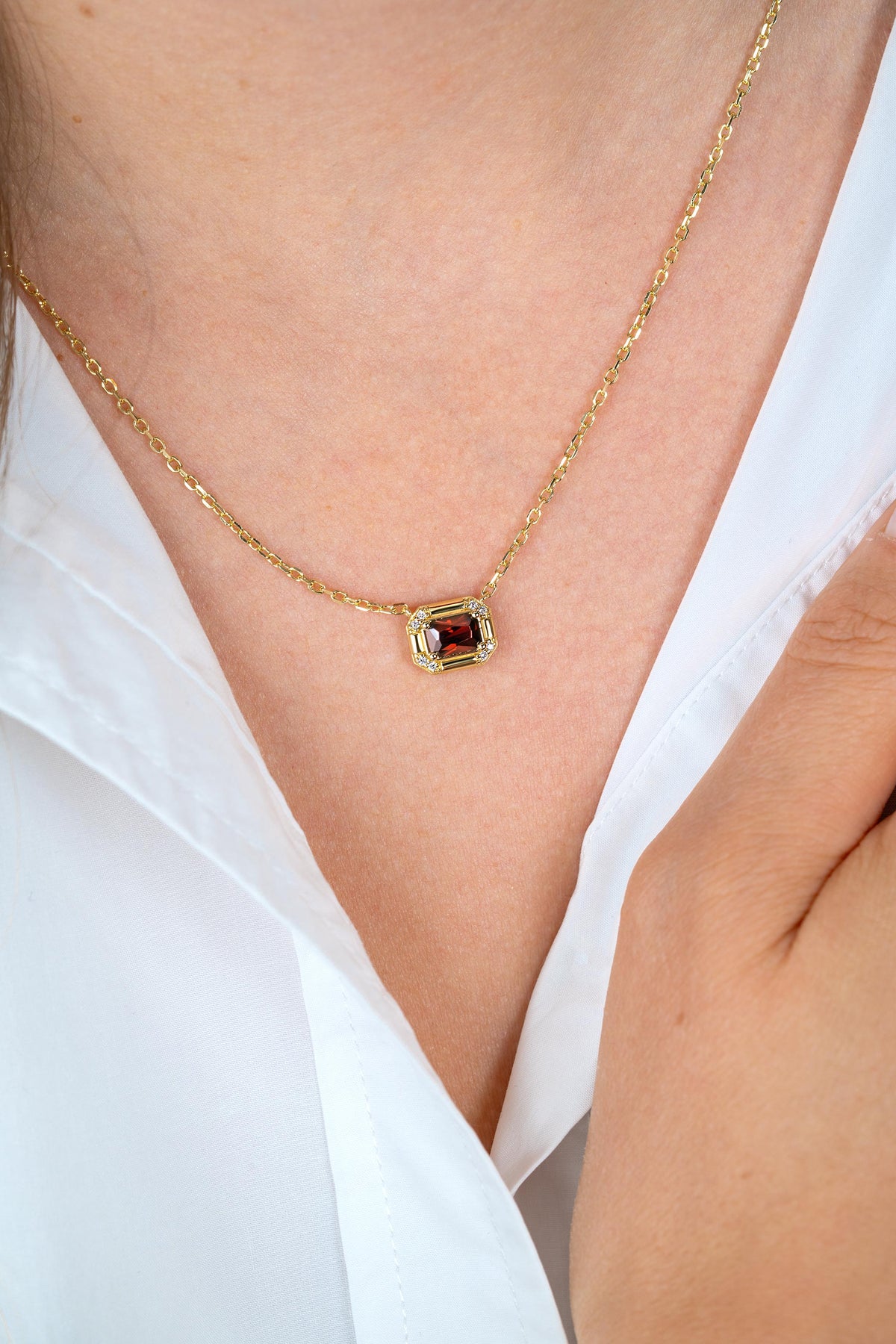 Collar de plata bañado en oro de 45 cm con un colgante rectangular y piedra roja.