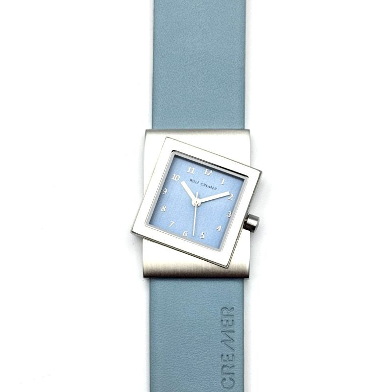 Reloj cuadrado con esfera azul claro y correa de silicona azul.