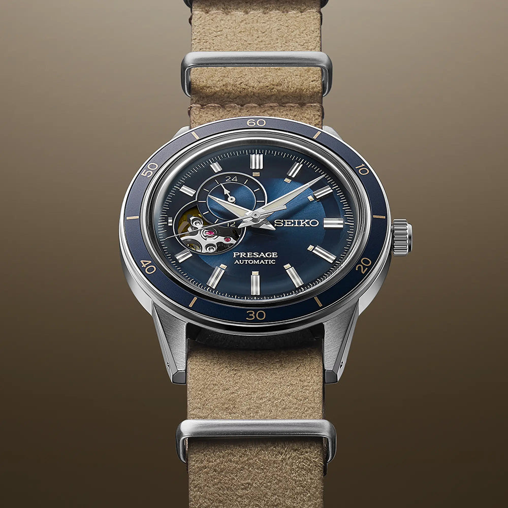 Het Seiko Presage heren horloge SSA453J1 heeft een blauwe metalen wijzerplaat, zichtbare tandwielen en een beige leren band. Het open-hart ontwerp versterkt de strakke bruine achtergrond en wordt beschermd door Hardlex mineraal glas—een prachtig automatisch horloge om elke outfit te verheffen.