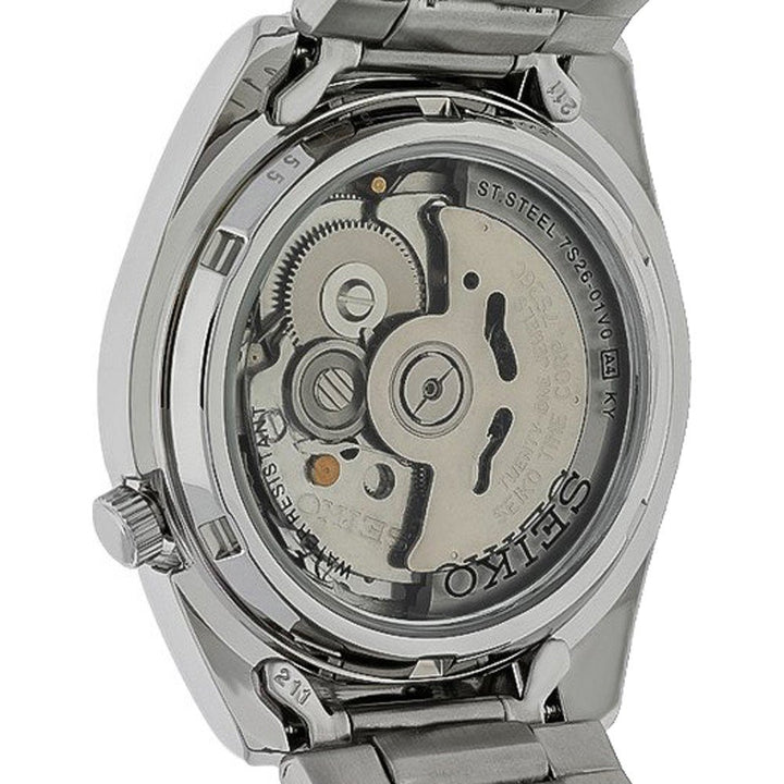 Een close-up van de achterkant van het Seiko heren horloge SNKL45K1 onthult het blootgestelde automatische uurwerk. De roestvrijstalen kast en componenten, samen met ingewikkelde tandwielen, zijn zichtbaar. De metalen band complementeert het ontwerp en SEIKO is elegant gegraveerd op de rotor.