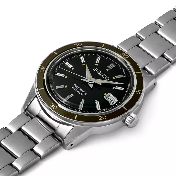 Het Seiko Presage heren horloge SRPG07J1 heeft een groene en zwarte wijzerplaat met zilveren uurmarkeringen en wijzers, een datumweergave op 3 uur en minutenmarkeringen op een roestvrijstalen lunette. Het heeft een roestvrijstalen band en wordt aangestuurd door een automatisch uurwerk.
