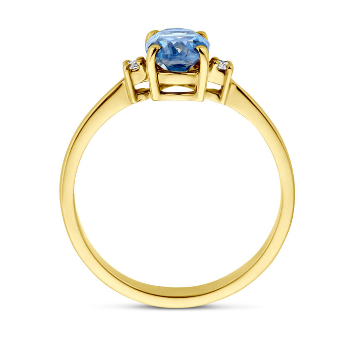 De ringtrilogie van de Van der Kooij Collectie heeft een 14K geelgouden band met een ronde Londensblauwe topaas in het midden, geflankeerd door diamanten (0,04ct H SI) aan elke zijde van de centrale steen.