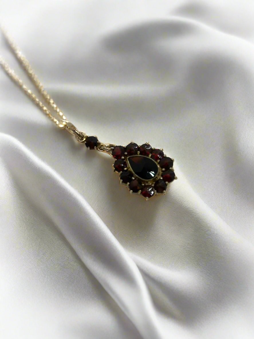 Colgante vintage de oro de 14k con granate, forma de gota y detalles florales.