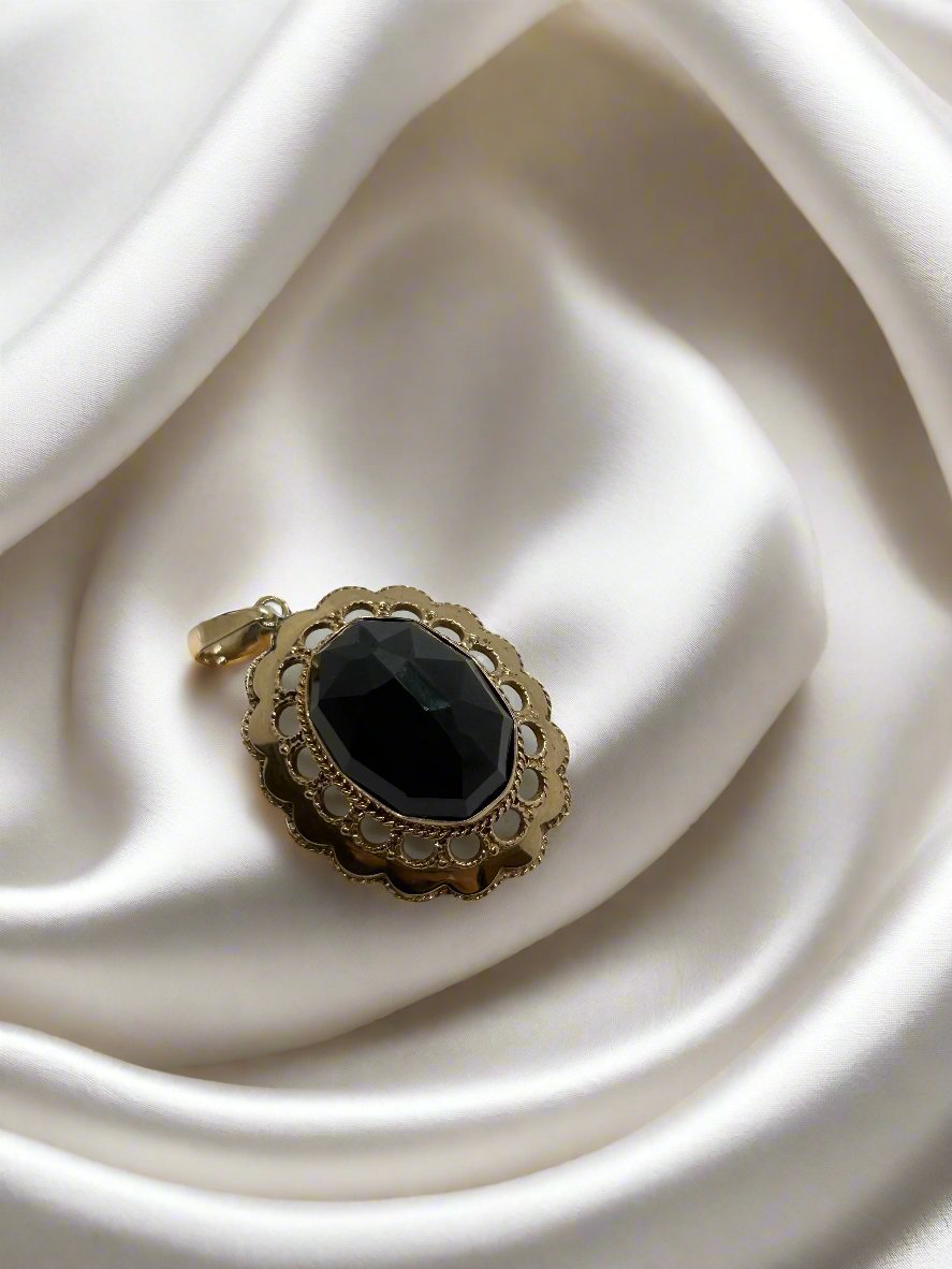 Colgante vintage de oro de 14k con granate negro y diseño de filigrana.