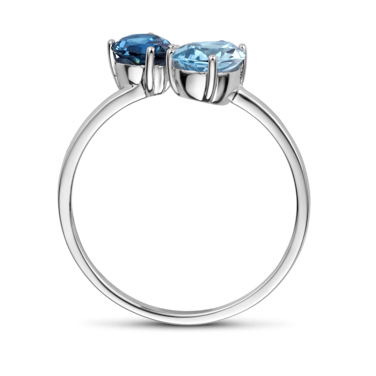 Een close-up zijaanzicht van de Van der Kooij Collectie ring trilogie in 14K witgoud, gezet met een London blauwe topaas, een blauwe topaas en een 0.01ct H P1 diamant, elke edelsteen stevig vastgehouden door prongs.