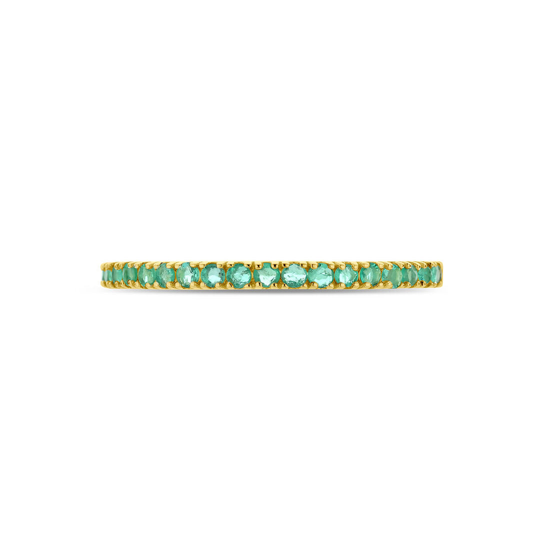 Een delicate 14K geelgouden "ring met geboortesteen smaragd mei" van de Van der Kooij Collectie, bezet met kleine smaragden in een doorlopende rij, gefotografeerd tegen een witte achtergrond.