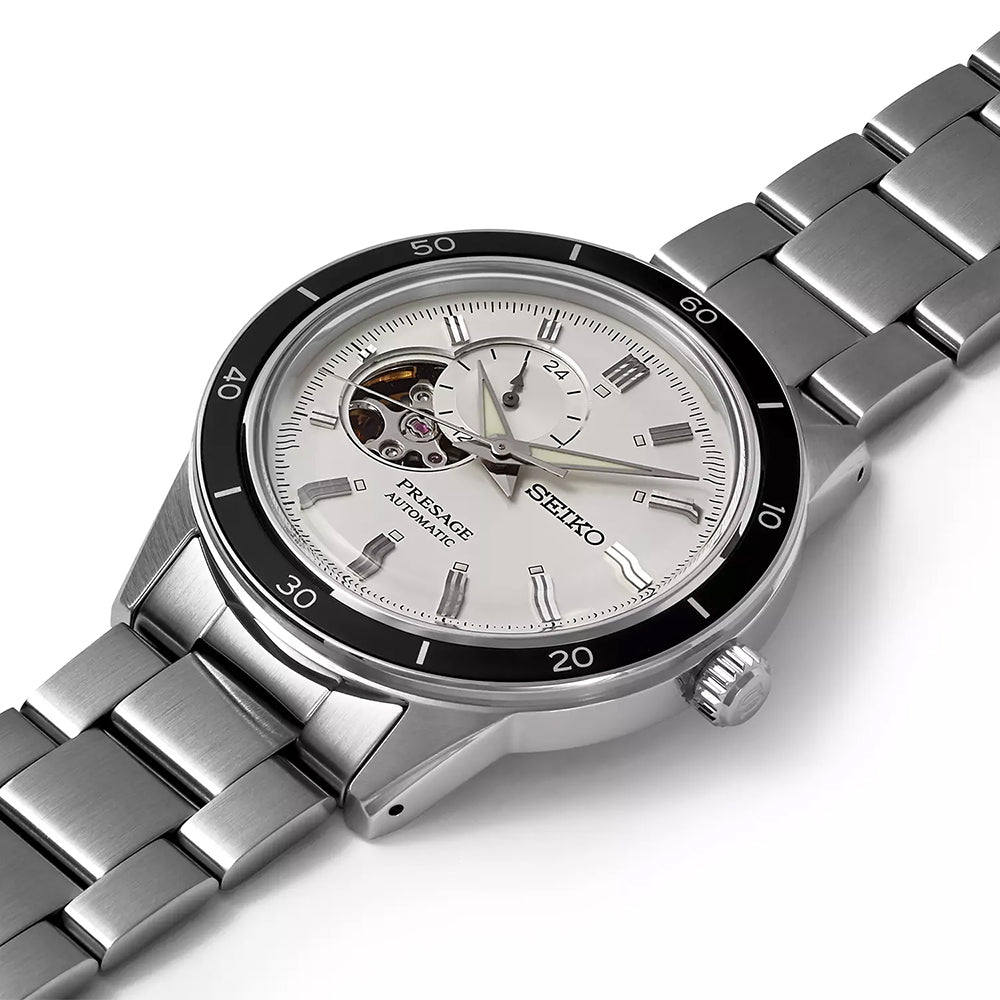 Close-up van een Seiko Presage heren horloge SSA423J1 met een roestvrijstalen kast, witte wijzerplaat, opengewerkt venster waarin het automatische uurwerk zichtbaar is, roestvrijstalen band en zwarte lunette met minutenmarkeringen.