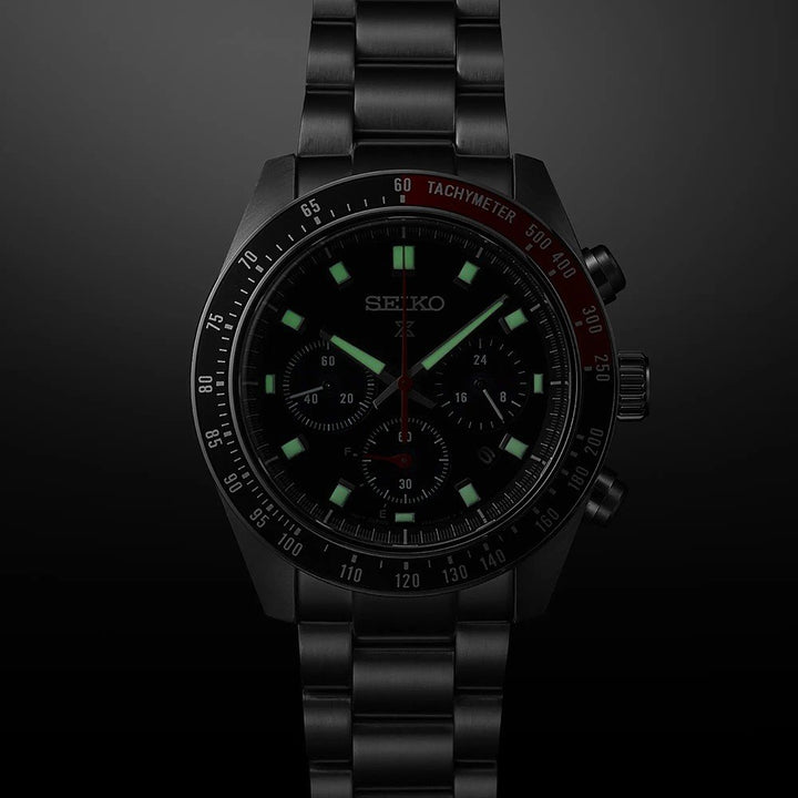De Seiko Prospex SSC915P1 heeft een metalen band, lichtgevende uurmarkeringen en wijzers, een subtiel zichtbare tachymeterschaal en zonnetechnologie voor langdurige energie. De merknaam verschijnt vaag op de donkere gradiënt wijzerplaat.