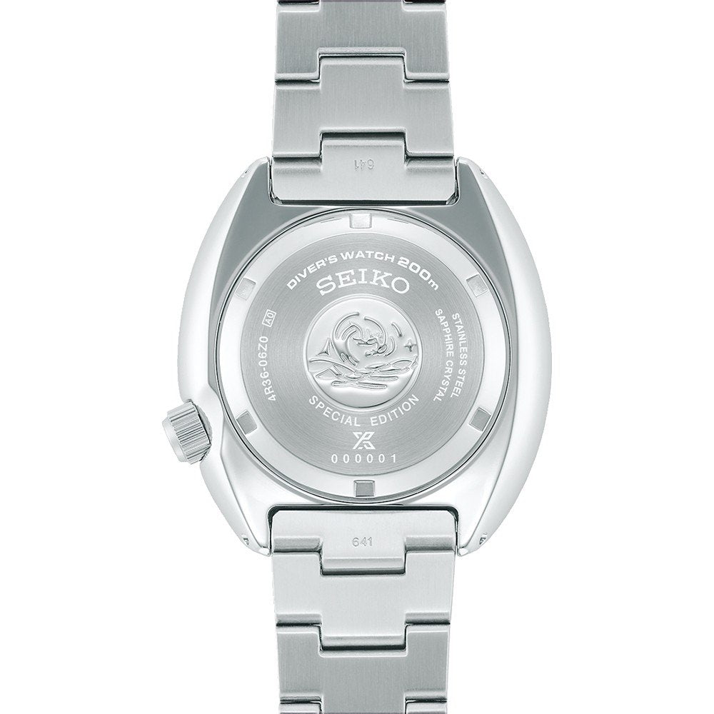 De afbeelding toont de achterkant van een Seiko Prospex heren horloge SRPK01K1 duikhorloge, met gegraveerde tekst en een decoratief ontwerp. Dit speciale zilveren exemplaar wordt geleverd met een metalen band en een automatisch uurwerk voor nauwkeurige tijdwaarneming.