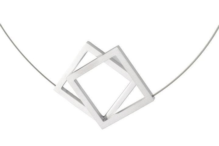 De Collier Twee grote vierkanten C104 van CLIC Creations is een minimalistische ketting met twee in elkaar grijpende open vierkante hangers in een zilveren afwerking. Handgemaakt in Nederland, het heeft een geometrisch ontwerp op een dunne draadketting, wat een moderne en stijlvolle look biedt tegen wit.