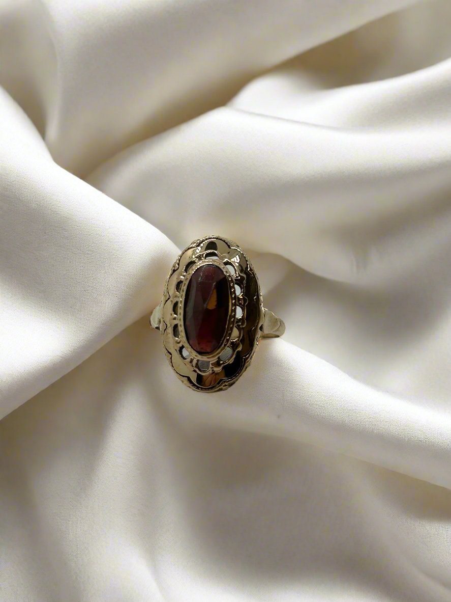 Anillo vintage de oro de 14k con granate ovalado y detalle de filigrana.