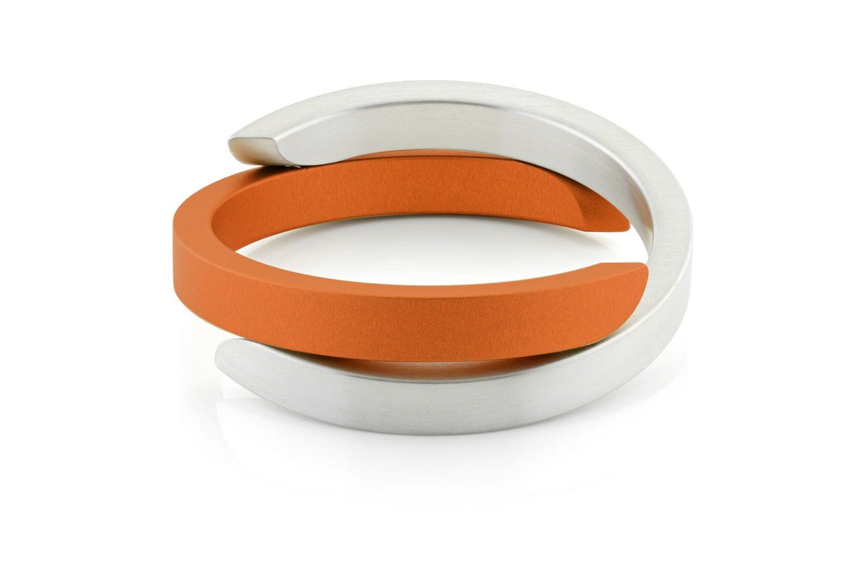 Pulsera de metal plateado con detalles en color naranja, de diseño cruzado y moderno.