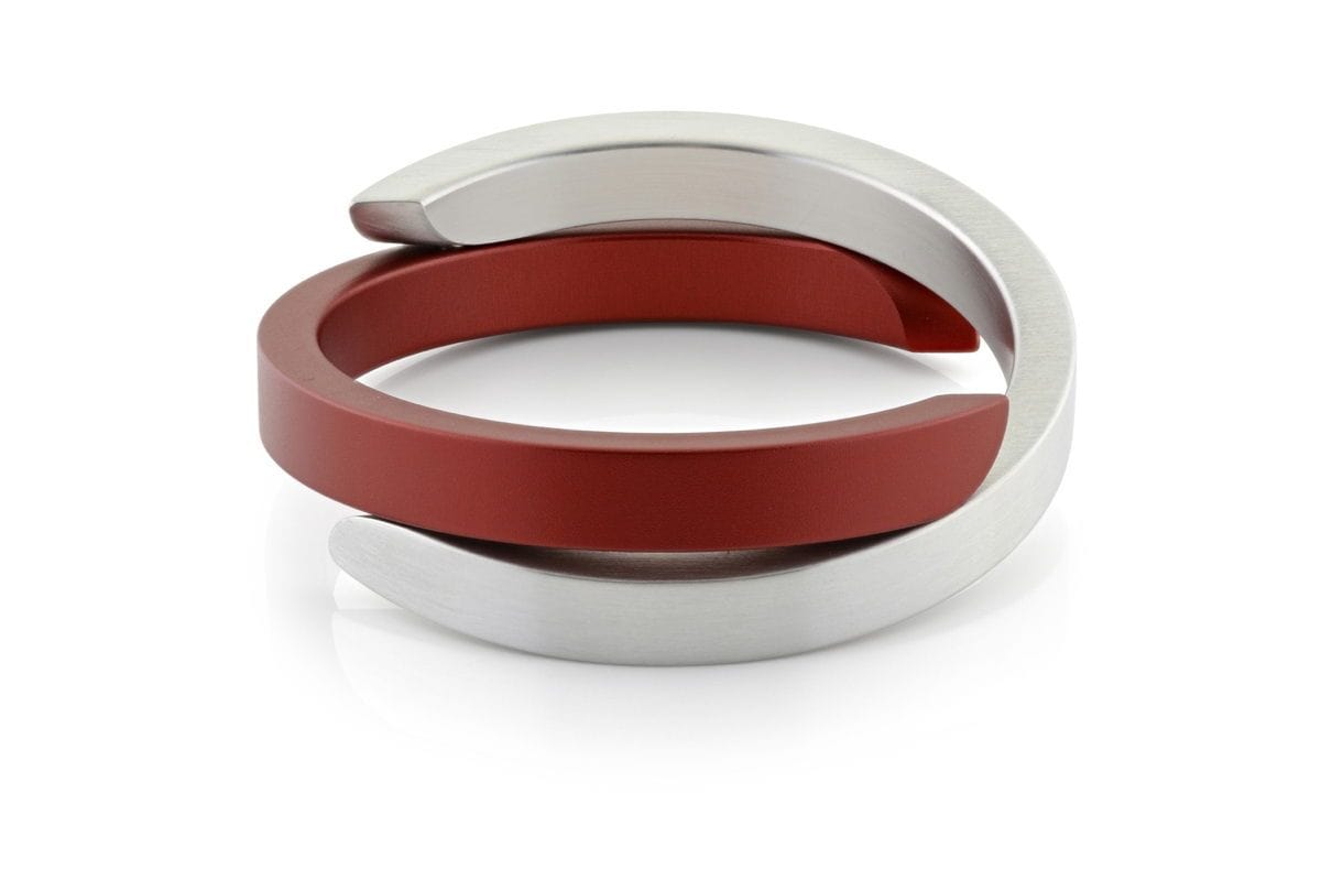Pulsera cruzada de color rojo y plateado con diseño moderno y acabado mate.