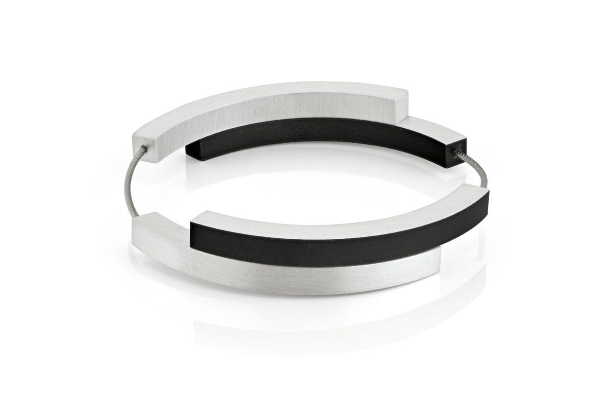 Pulsera de cuatro arcos en negro y plata, con un diseño moderno y minimalista.