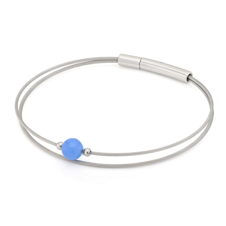 De Thinking of You Armband Agaat A714A van CLIC Creations heeft een minimalistisch ontwerp met een centrale blauwe kraal, twee dunne metalen strengen en een cilindervormige zilveren sluiting: een ideaal cadeau voor elke gelegenheid.