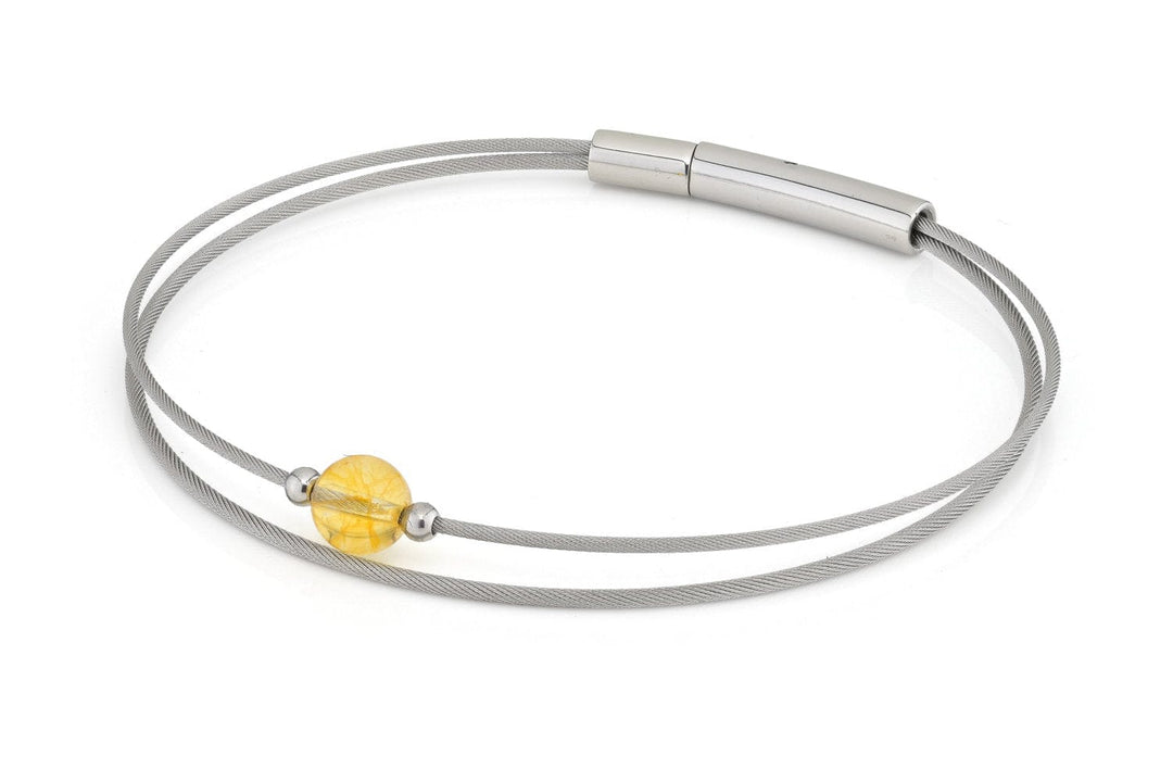 De Thinking of You armband Citrien A719B van CLIC Creations heeft een minimalistisch ontwerp met twee dunne zilveren bandjes en een cilindervormige sluiting, waarbij een ronde amberkleurige kraal elegant tussen twee kleine zilveren kraaltjes is geregen.