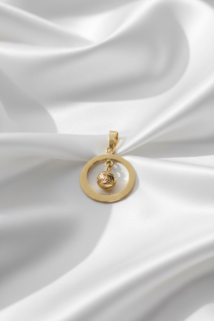 Colgante vintage de oro de 14k con un diseño circular y un detalle en forma de espiral.