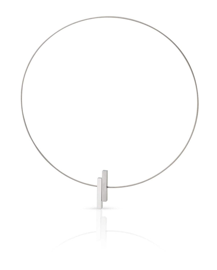 De Collier Eenvoudige staafjes C116 van CLIC Creations is een minimalistische choker gemaakt van edelstaal, met een dunne band met twee kleine rechthoekige blokjes. Dit unieke ontwerp biedt een eenvoudige, elegante esthetiek en wordt vastgezet met een discrete magnetische sluiting.