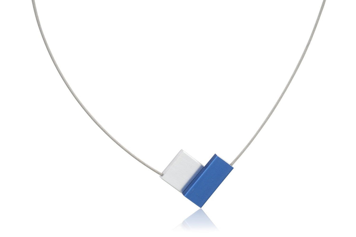 Collar en forma de V con detalles en azul y blanco, sobre cadena delgada plateada.