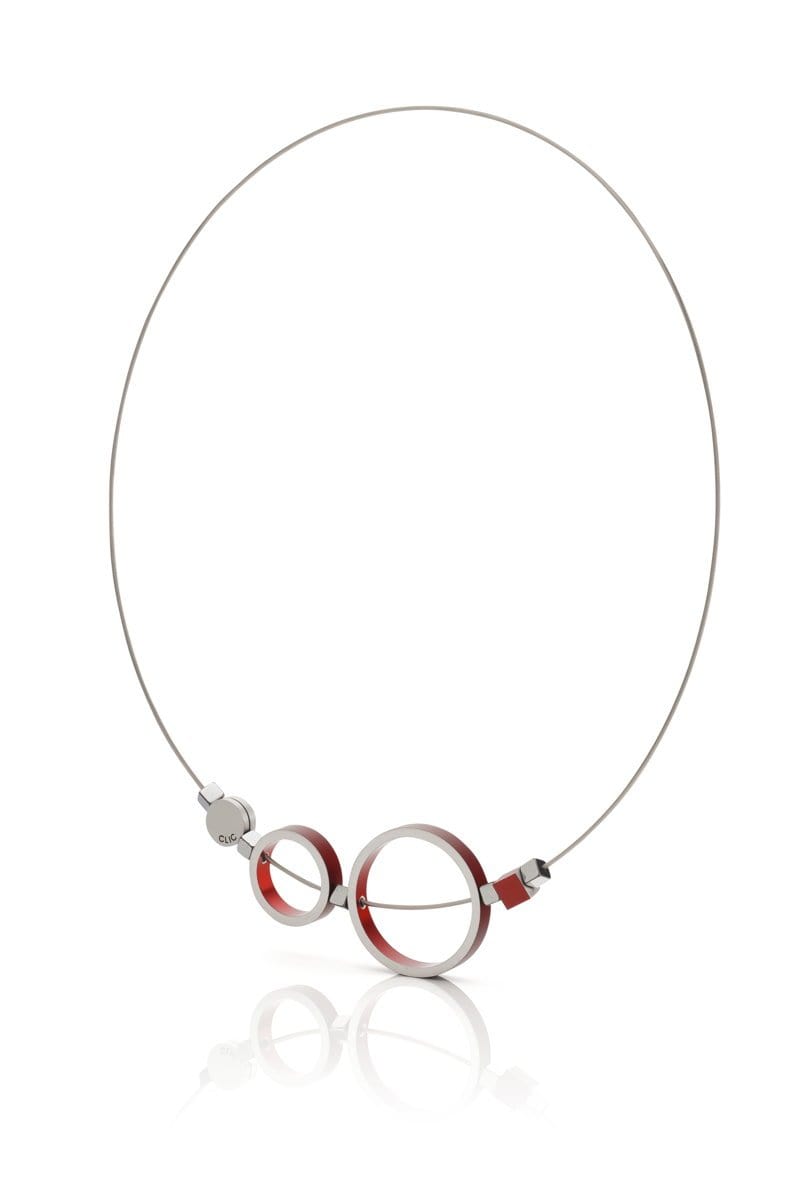 Collar con anillos rojos y detalles plateados, diseño moderno y minimalista.