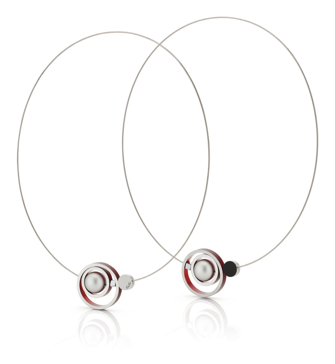 De Collier Ringen in elkaar Rood C187R van CLIC Creations zijn minimalistische zilveren creolen met een centrale metalen bol, omringd door rode en zwarte ringen. Handgemaakt in Nederland, ze bieden een modern, geometrisch ontwerp met reflecterende oppervlakken.