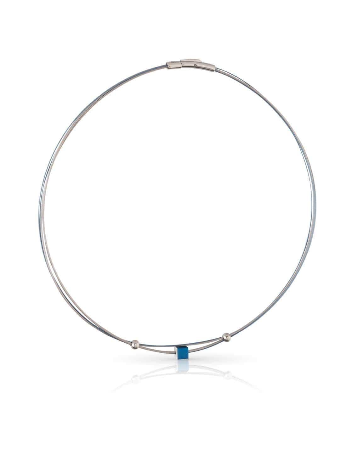 Collar de metal plateado con un pequeño cubo azul en el centro y detalles esféricos.