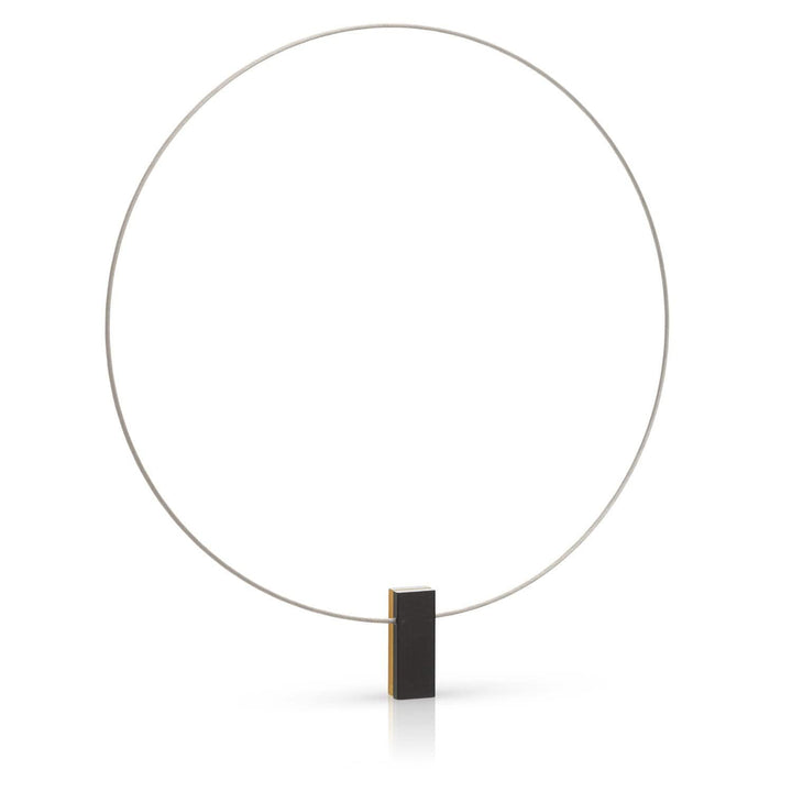 De CLIC Creations Collier twee gekleurde rechthoeken C232GZ is een minimalistisch, met de hand gemaakt Nederlands beeldhouwwerk. Het bestaat uit een grote, dunne, verticale metalen cirkel die wordt ondersteund door een klein rechthoekig blok met één zijde in een contrasterende kleur, tegen een effen witte achtergrond.